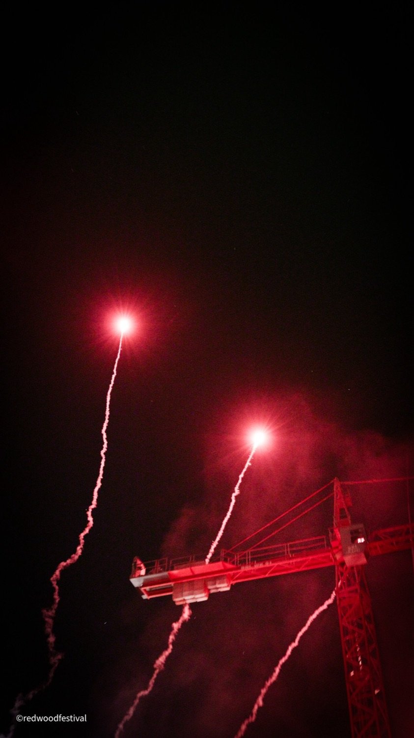 Zwei rote Raketen mit Leuchtspur über einem Baukran